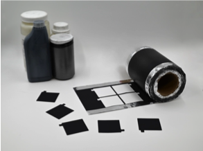 Battery electrode materials that make Ateios Systems' patented product Rai Core on display. Black solid matter in jars, roll of electrode coated in Rai Core product against light background.